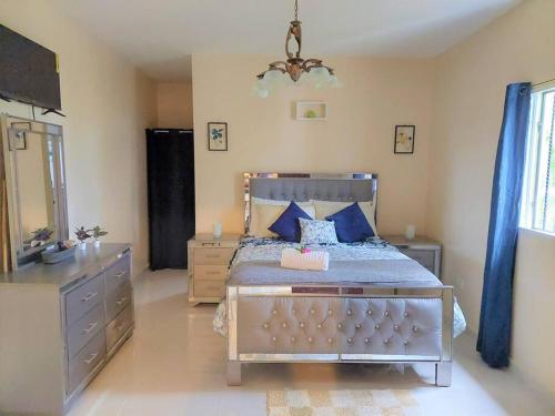 a bedroom with a bed with a dresser and a mirror at Villa Familiar en Río San Juan con Wifi BBQ Piscina @drvacationsrental in Río San Juan