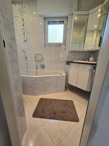 a bathroom with a tub and a shower with a rug at Sarahs Ferienhaus in Raunheim