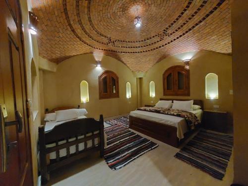 una camera con due letti in una stanza con soffitto di فيلا الريف السويسري a Tunis