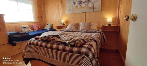 ein Schlafzimmer mit einem Bett mit einer Decke darauf in der Unterkunft Cabañas Casas Alto Madero in Las Cruces