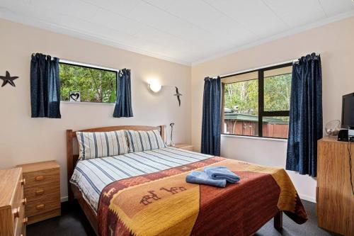 a bedroom with a bed and a window at Waters Edge Golden Bay in Collingwood