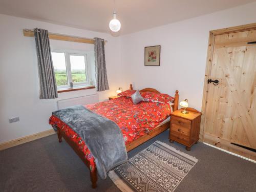 a bedroom with a bed and a window and a wooden door at Bridge End in Chatburn