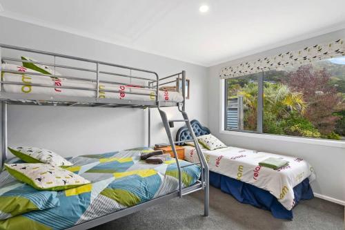 - une chambre avec 2 lits superposés et une fenêtre dans l'établissement Tata Beach All Aboard, à Tarakohe