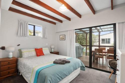 Schlafzimmer mit einem Bett und einer Glasschiebetür in der Unterkunft Parapara Beach Escape in Parapara 
