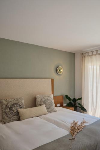 a bedroom with a large white bed and a window at Villa B&M Experience in Sant Francesc de s'Estany