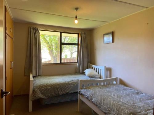 a bedroom with two beds and a window at Kiwi Holidays in Cromwell in Cromwell