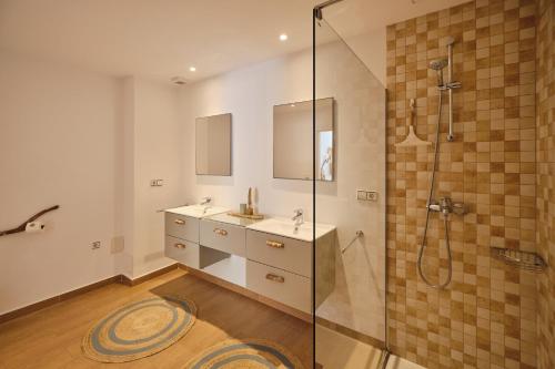 a bathroom with two sinks and a shower at Villa B&M Experience in Sant Francesc de s'Estany