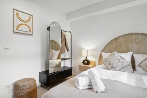 a white bedroom with a bed and a mirror at Casa Oasis IV: Modern, Nespresso & Thermennähe in Bad Füssing