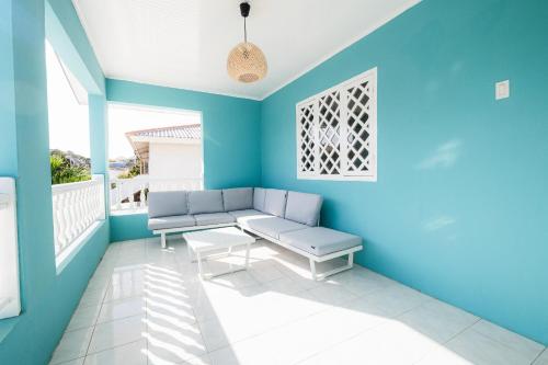 a blue room with a bench on a balcony at Villa Grandi - Cas Grandi in Willemstad