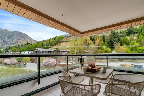 a room with a table and chairs and a large window at Coronet Base at La Residence du Parc in Queenstown