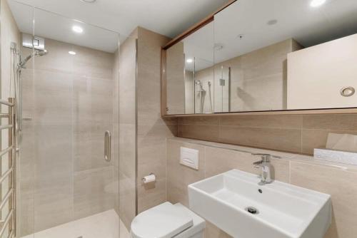 a bathroom with a toilet and a sink and a shower at Coronet Base at La Residence du Parc in Queenstown