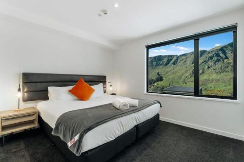 une chambre avec un lit et une grande fenêtre dans l'établissement La Residence du Parc, à Queenstown