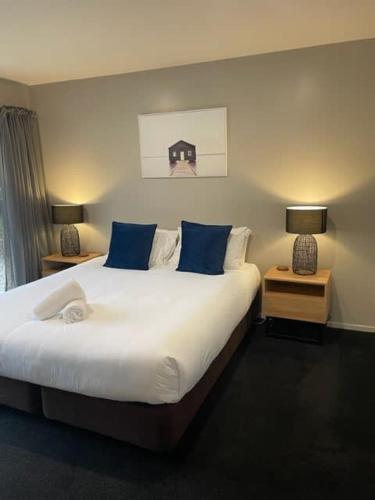 a bedroom with a large bed with blue pillows at Alpine Retreat in Wanaka