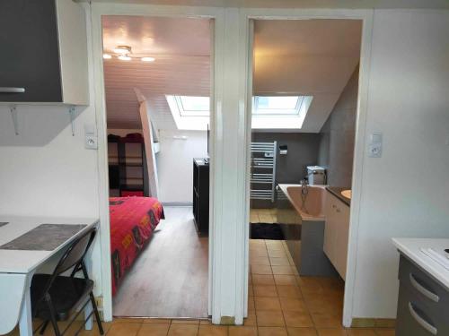 une chambre avec un lit et une cuisine avec une fenêtre dans l'établissement Petit appartement centre Vitré, à Vitré