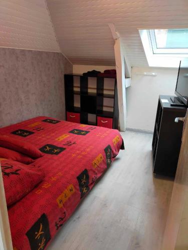 une chambre avec un lit avec une couverture rouge dans l'établissement Petit appartement centre Vitré, à Vitré