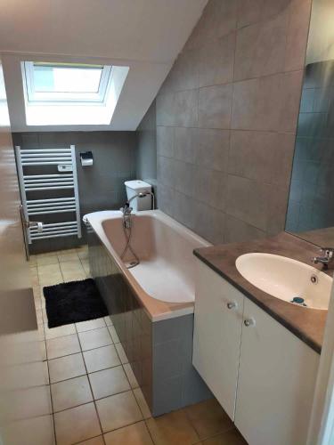 une salle de bain avec une baignoire et un lavabo dans l'établissement Petit appartement centre Vitré, à Vitré