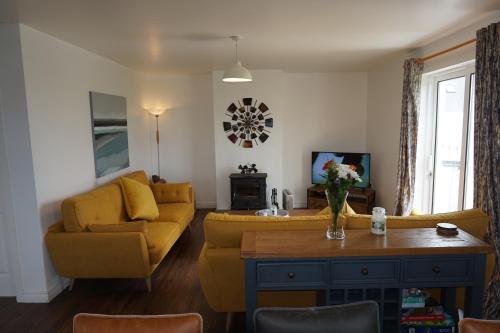 a living room with a yellow couch and a tv at 18 Ballybunion Holiday Cottages in Ballybunion