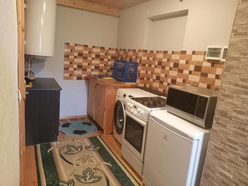 eine kleine Küche mit einem Herd und einer Mikrowelle in der Unterkunft Садиба "Три Царі" in Jaremtsche