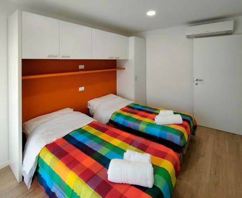 利尼亞諾薩比亞多羅的住宿－Casa Bivi 2，配有彩虹毯子的客房内的两张床