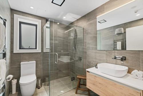 a bathroom with a toilet and a sink and a shower at Luxury Lake View Apartment in Wanaka