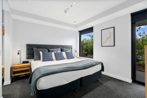 a bedroom with a large bed and a window at Cozy Coronet Peak Apartment at La Residence du Parc in Queenstown