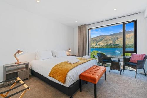 a bedroom with a large bed and a table and chairs at Lake View Studio Apartment in Wanaka
