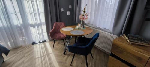 a small table and two chairs in a room with windows at Pension Villa Marit in Prague