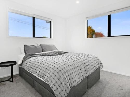 1 dormitorio blanco con 1 cama y 2 ventanas en Central Convenience on Armagh, en Christchurch