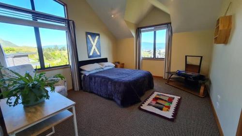 a bedroom with a bed and a large window at Bay Views on Bay Vista in Pohara