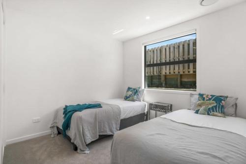 a bedroom with two beds and a window at Vacations on Riverslea in Wanaka