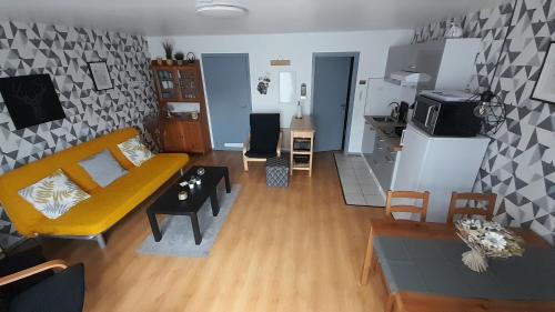 ein Wohnzimmer mit einem gelben Sofa und einem Tisch in der Unterkunft Le Sentier des Lavandes in Vresse-sur-Semois