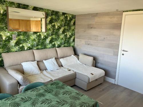 een woonkamer met een bank en een tafel bij Bel Acacia in De Haan