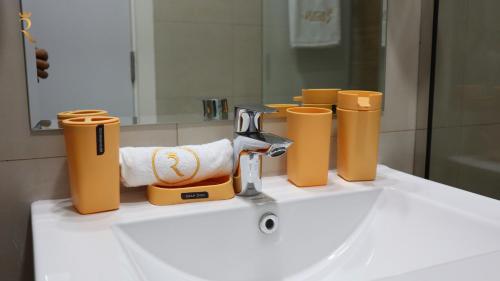 a bathroom sink with a faucet and towels on it at 2BR Duplex Transit apartment Coral. in Abu Dhabi