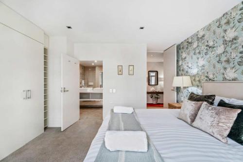 a bedroom with a large white bed with a couch at Pembroke Luxury Apartment in Wanaka