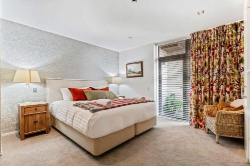 Pembroke - Luxury 1 Bedroom Apartment في واناكا: غرفة نوم بسرير كبير ونافذة