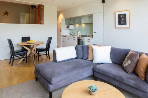 een woonkamer met een bank en een tafel bij Stunning Lakeview 1 Bedroom Apartment in Queenstown