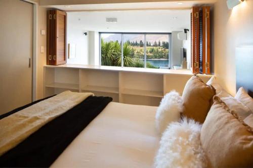 een slaapkamer met een bed en een groot raam bij Stunning Lakeview 1 Bedroom Apartment in Queenstown