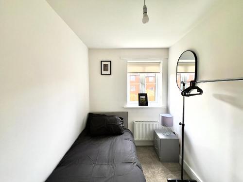 ein kleines Schlafzimmer mit einem Bett in der Ecke in der Unterkunft BRAND NEW 3 BEDROOM HOUSE WITH GARDEN AND FREE PARKING in Wednesbury