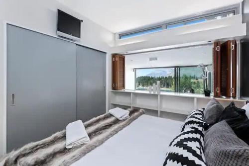 a bedroom with a large bed with a large window at Luxury Lake View - 1 Bedroom in Queenstown