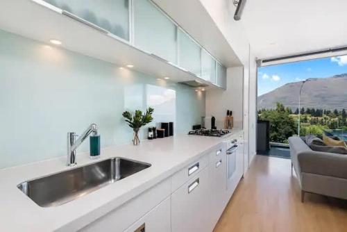 a kitchen with a sink and a large window at Luxury Lake View - 1 Bedroom in Queenstown