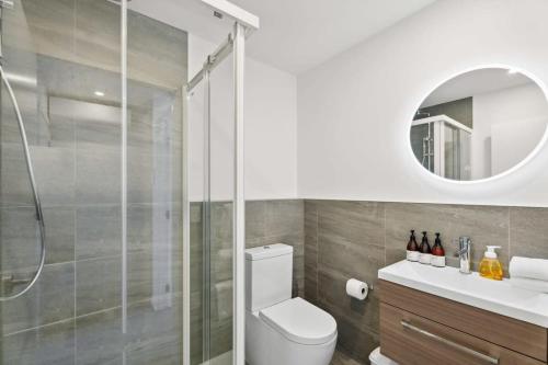 a bathroom with a shower and a toilet and a mirror at Rivers Edge - Alberttown in Albert Town