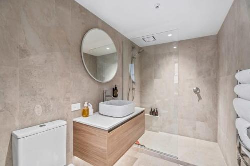 a bathroom with a sink and a toilet and a mirror at Tranquil Modern Studio in Queenstown