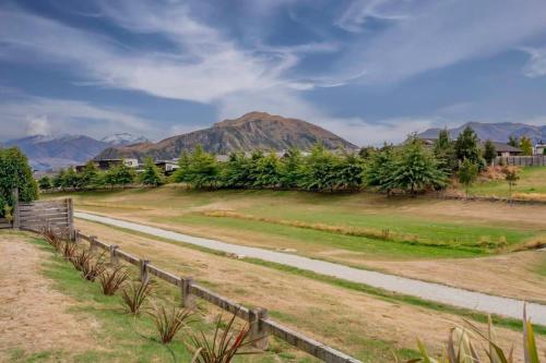 a dirt road with a mountain in the background at Sunny Dreams in Wanaka
