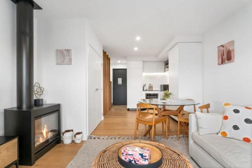 a living room with a couch and a fireplace at Wanaka Riverside Townhouse Retreat in Albert Town