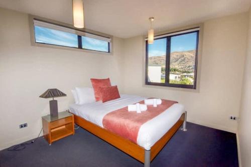 a bedroom with a large bed with a window at Mataraki Magic in Wanaka