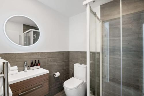 a bathroom with a toilet and a glass shower at Albert Town Whare in Albert Town