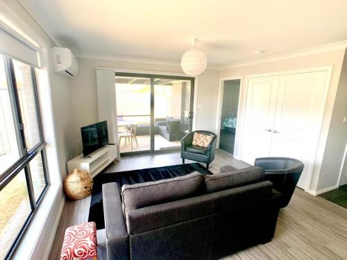 a living room with a couch and a television at Modern Majestic - Everything you need Neat & Tidy in Orange