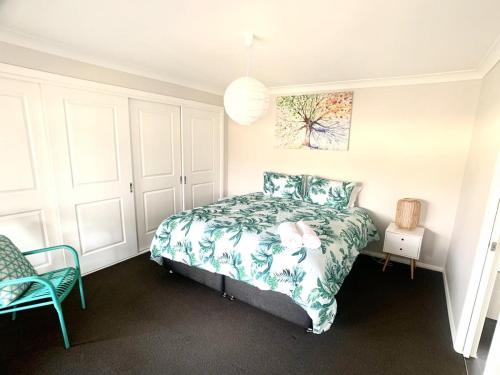 a bedroom with a bed and a chair at Modern Majestic - Everything you need Neat & Tidy in Orange