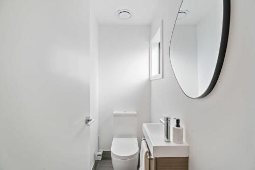 a white bathroom with a sink and a mirror at Wanaka Hararei in Albert Town