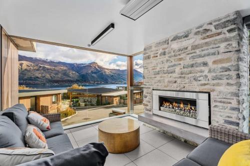 a living room with a stone wall and a fireplace at Lakeview Luxury Vista in Wanaka